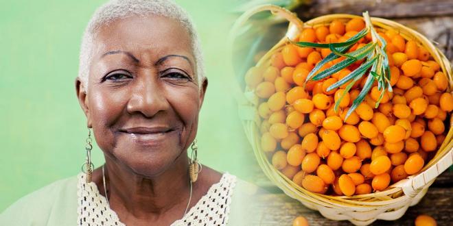 beautiful african american woman and a basket of sea buckthorn berries